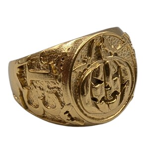 Puede incluir: Un anillo de color dorado con un dise&ntilde;o detallado que presenta una cara de calabaza. El anillo est&aacute; hecho de metal y tiene una superficie texturizada.