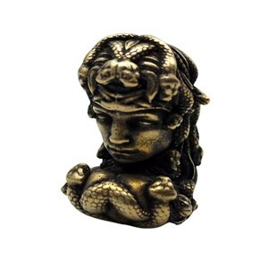 Puede incluir: Una escultura de metal dorado de Medusa, la figura mitol&oacute;gica griega con serpientes por cabello. La escultura est&aacute; detallada con serpientes envueltas alrededor de su cabeza y cuello.
