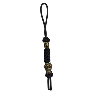 May include: Black paracord keychain with a gold skull bead and a gold bead with a decorative design.