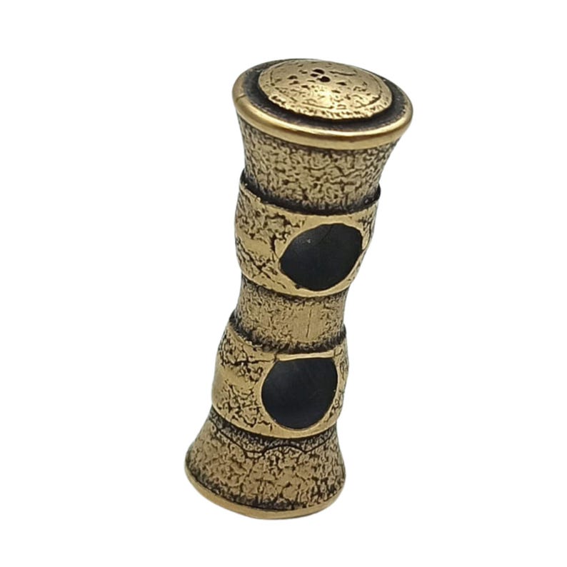 May include: A gold-coloured metal bead with two circular holes. The bead has a textured surface and a rounded top.