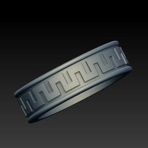 May include: A silver-toned metal ring featuring a continuous embossed Greek key pattern around the outer band. The design consists of a repeating geometric meander motif set against a smooth, matte-finished surface with raised edges.