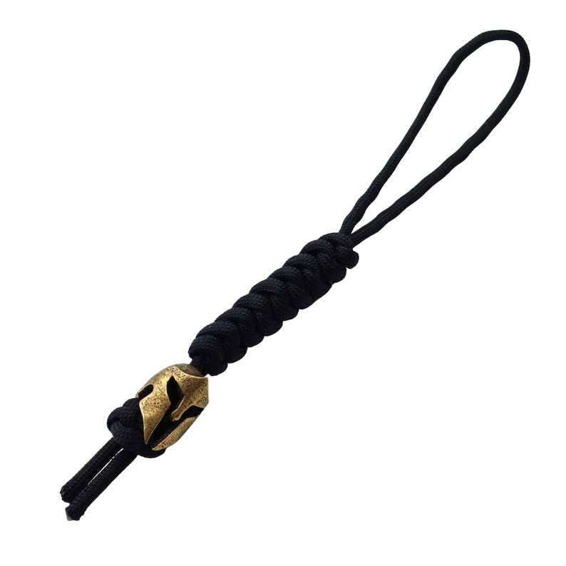May include: Black paracord keychain with a gold-colored Spartan helmet bead.