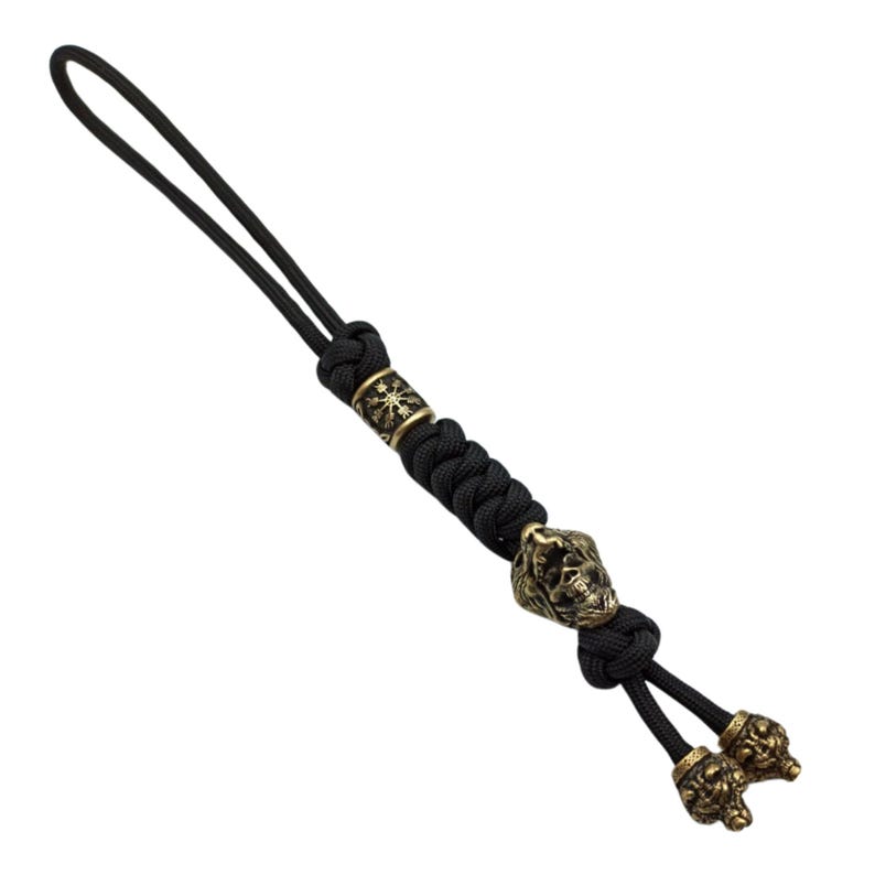 May include: Black paracord keychain with a brass skull bead and two smaller brass beads with a wolf design.