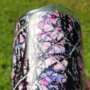 May include: A black and pink camouflage tumbler with a glossy finish. The design features a pink and white camouflage pattern with black accents.