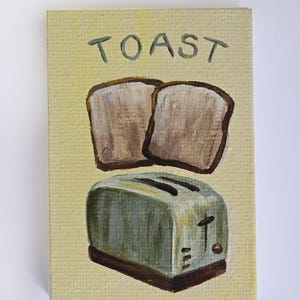 Op de afbeelding: Een handgeschilderde illustratie van een broodrooster en twee sneetjes brood. De achtergrond is geel en de tekst "TOAST" is in het groen boven de broodrooster geschreven.