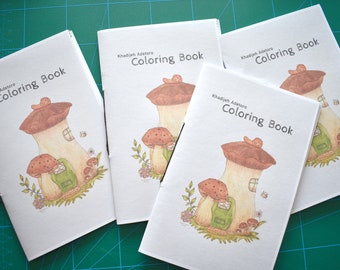 May include: Four white coloring books with mushroom illustrations. Each book has the title "Khadijeh Adetoro Coloring Book" printed on the cover.