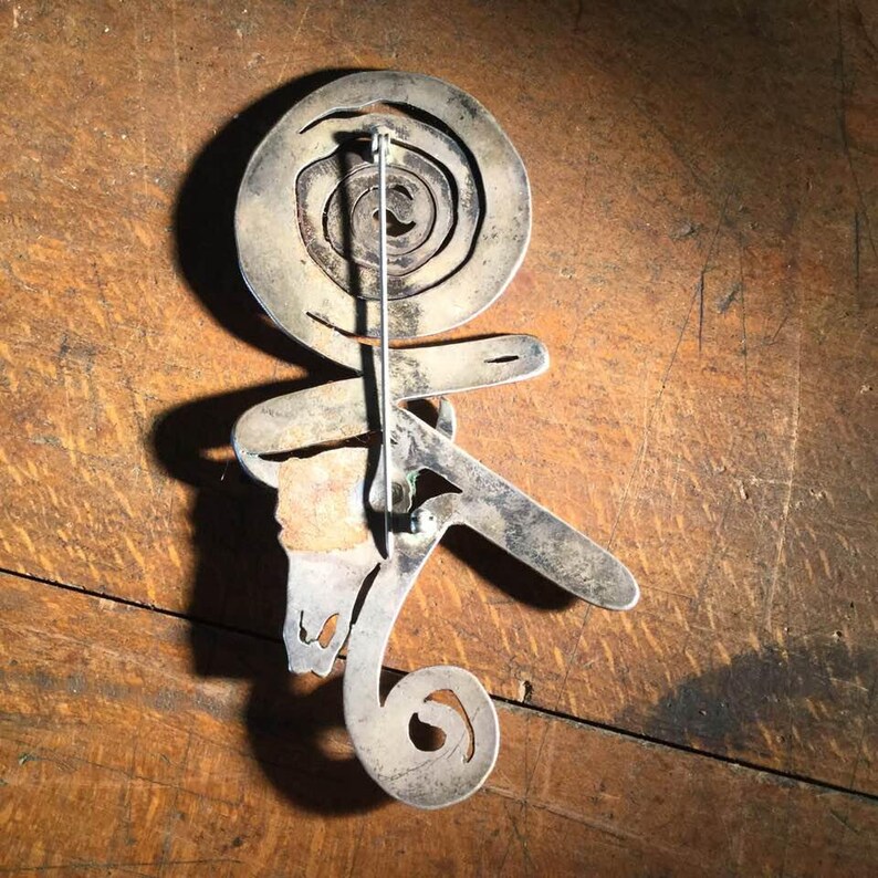 silver and brass brooch