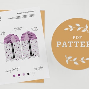 May include: A printable PDF pattern for a beaded umbrella, using Miyuki Delica beads. The pattern includes instructions for brick stitch and fringe. The pattern is available in purple, white, and black.