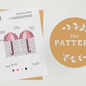 May include: A printable PDF pattern for a beaded umbrella, featuring a pink and burgundy color scheme. The pattern includes instructions for a fringe brick stitch and a color key for the beads. The text "PDF PATTERN" is displayed in a circle with a floral design.