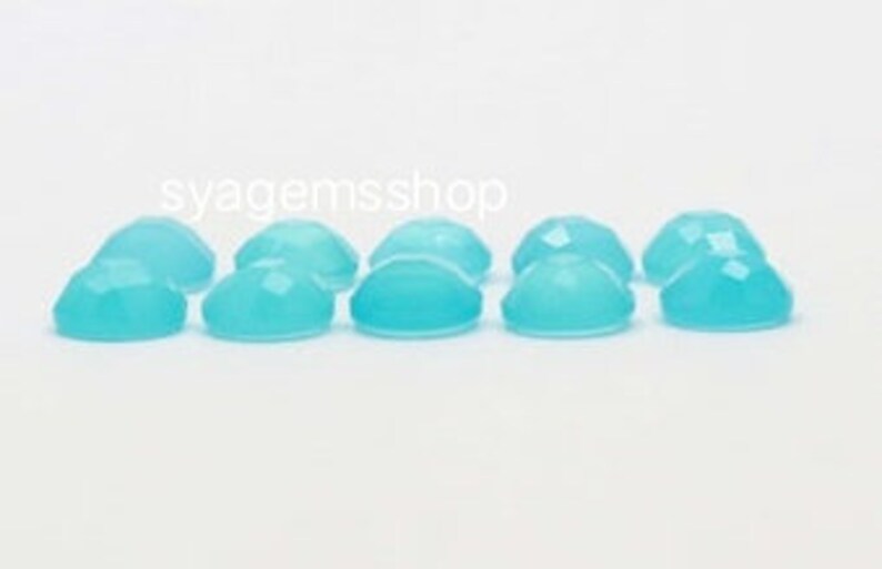 Puede incluir: Diez piedras preciosas cabuj&oacute;n de forma ovalada facetadas, de color azul claro.