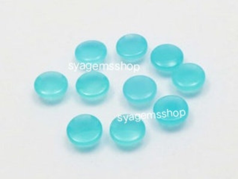 Puede incluir: Diez piedras preciosas cabuj&oacute;n redondas de color azul claro.