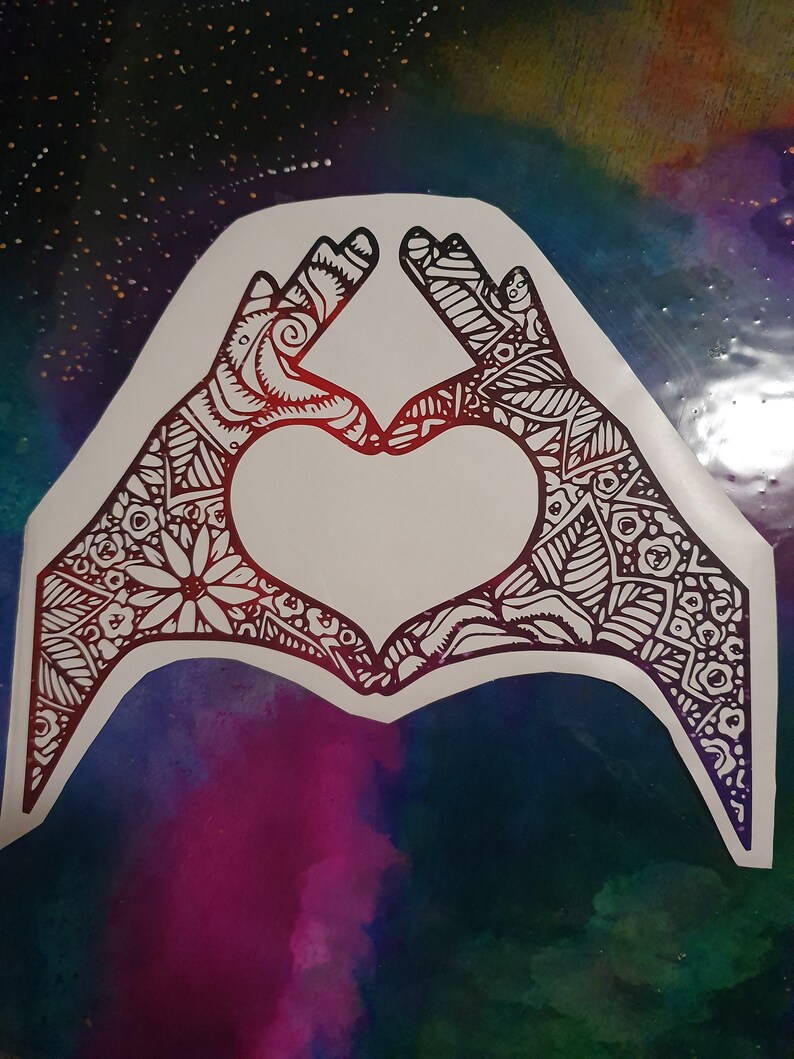 Pu&ograve; includere: Due mani che formano un cuore con intricati motivi in ​​bianco e nero su uno sfondo colorato.