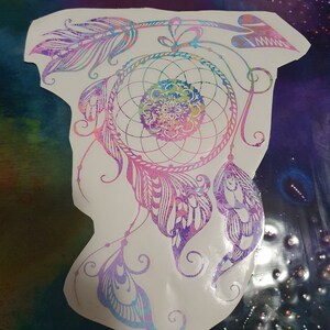 Pu&ograve; includere: Un acchiappasogni colorato con piume e un design a perline. L'acchiappasogni &egrave; un simbolo popolare di buoni sogni e protezione.