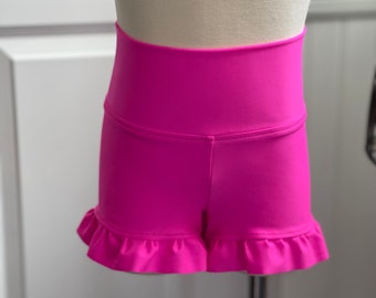 Könnte beinhalten: Knallrosa Shorts mit hoher Taille und Rüschen am Saum.