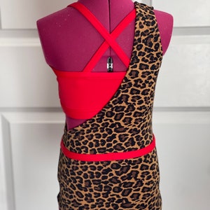 May include: A red and brown leopard print dance leotard with a criss-cross strap back.