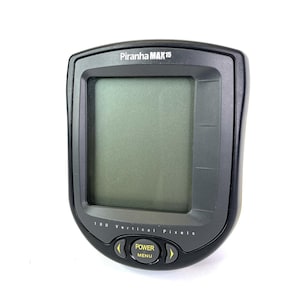 May include: A black Piranha MAX 15 fish finder with a rectangular screen and yellow buttons. The device has the text "Piranha MAX 15" at the top and "160 Vertical Pixels" at the bottom. The buttons are labeled "Power" and "Menu".