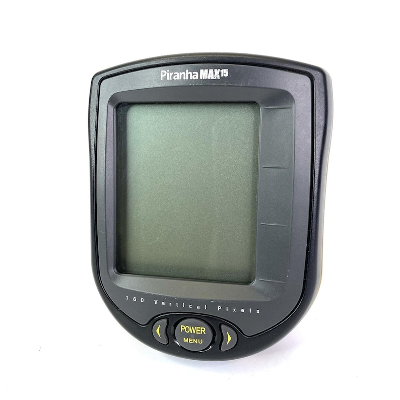 May include: A black Piranha MAX 15 fish finder with a rectangular screen and yellow buttons. The device has the text "Piranha MAX 15" at the top and "160 Vertical Pixels" at the bottom. The buttons are labeled "Power" and "Menu".