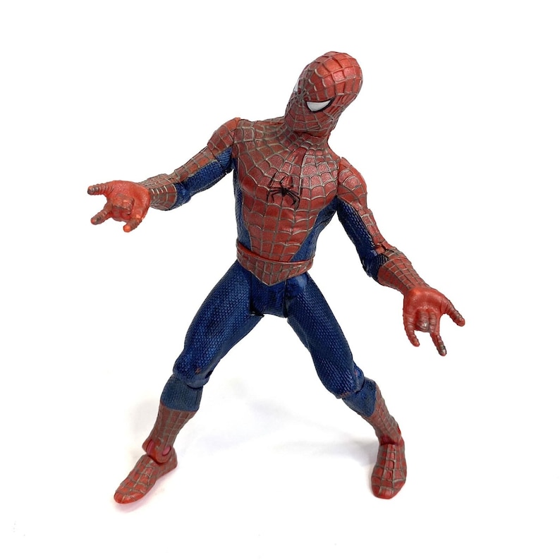 May include: A Spider-Man action figure in a dynamic pose, featuring a red and blue costume with a spider emblem on the chest. The figure has articulated joints and is set against a white background.