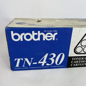 May include: A blue and white Brother TN-430 toner cartridge box. The box features the Brother logo, the text "TN-430", and the phrase "At your side." The box also indicates a yield of 3000 pages at 5% coverage.