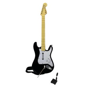 May include: Black and white Fender Stratocaster guitar controller with a cream-colored neck and headstock. The guitar has a white pickguard, a whammy bar, and a black strap. A black USB adapter and foot pedal are included.