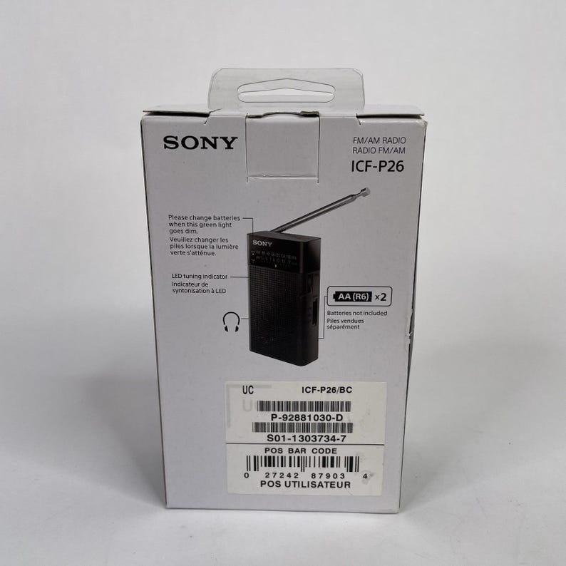 May include: A boxed black Sony ICF-P26 FM/AM radio. The packaging displays the Sony logo, product information, and an image of the radio with its antenna extended. The box also includes text about battery replacement and a tuning indicator.