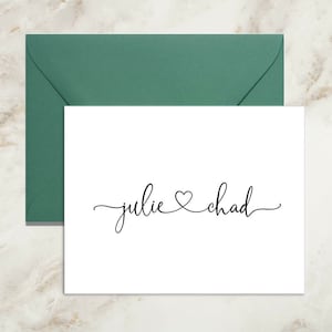May include: A white card with the names "julie" and "chad" written in cursive script with a heart symbol between the names.