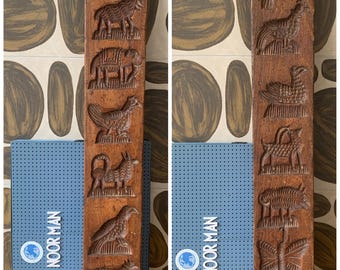 May include: Two antique wooden molds with carved animal designs. One mold features a swan, goat, elephant, and rooster. The other mold has a bird, dog, duck, and butterfly. The molds are brown and have a rectangular shape.