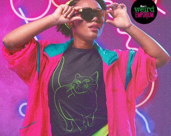 May include: A woman wearing a black t-shirt with a neon green outline of a cat. The t-shirt is under a pink and teal jacket. The woman is wearing sunglasses and has a neon green and black headband. The background is a purple and pink gradient with neon pink and white lines.