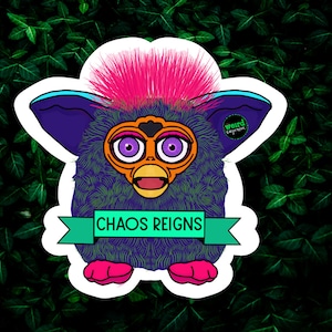 May include: A purple and blue fuzzy toy with pink hair and a yellow beak. The toy has large purple eyes and a green banner that says "Chaos Reigns".