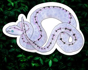 May include: A sticker featuring a purple and black snake with a blue eye, curled up in a circle. The snake is on a green leafy background.