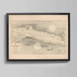 Op de afbeelding: Ingelijste vintage kaartprint van de rivier de Forth, met gedetailleerde cartografie in beige en grijs. De kaart bevat navigatiedetails en kompasrozen, omlijst in een zwart frame.