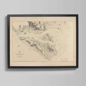 Può includere: Carta nautica vintage incorniciata di New Harbor, Maine, in una cornice nera. La carta presenta informazioni topografiche e batimetriche dettagliate in tonalità beige e grigie, con testo in basso. Un pezzo classico per l'arredamento costiero.