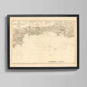 May include: Framed vintage nautical chart titled "Approaches to Plymouth." The map features detailed coastlines, depth soundings, and navigational markers in black ink on a cream-colored background. The black frame adds a classic touch.