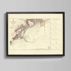 Könnte beinhalten: Gerahmte Vintage-Seekarte des Dover Harbour mit detaillierten Illustrationen der Küstenlinie, Meerestiefen und Navigationsmarkierungen. Die Karte ist in Sepiatönen mit grünen und braunen Akzenten gehalten und in einem schwarzen Rahmen.