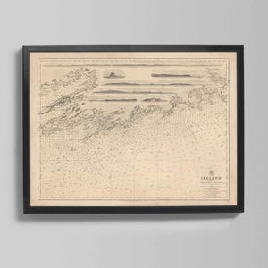 Puede incluir: Mapa antiguo enmarcado de Irlanda, con cartas náuticas detalladas y características geográficas. El mapa está impreso en papel envejecido y enmarcado en un marco negro, adecuado para la decoración del hogar. La palabra "Ireland" es visible.