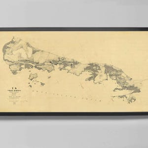 May include: Framed vintage map of a coastal area, featuring detailed land and water features in shades of gray and beige. The map is labeled "US Coast Survey" and is encased in a black frame, suitable for home decor.