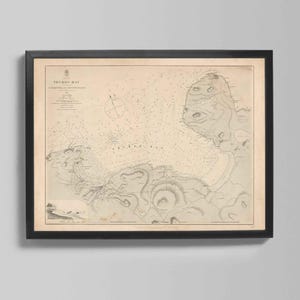 May include: Framed vintage map of the Yuru Bay area, featuring detailed nautical charts and topographical lines. The map is printed on aged paper and encased in a black frame, suitable for home decor.