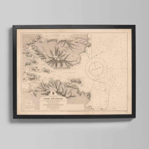 May include: Framed vintage map of Loch Boisdale, featuring detailed nautical charts and topographic details. The map is in sepia tones, framed in a black border, and mounted on a light gray wall. The map includes text at the bottom.