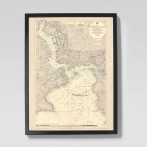 Może przedstawiać: Oprawiona mapa morska Portsmouth Sound w czarnej ramie. Mapa zawiera szczegółowe linie brzegowe, drogi wodne i znaki nawigacyjne. Mapa jest wydrukowana w odcieniach sepii, z tytułem "Portsmouth Sound, New Hampshire" u góry.