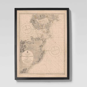 Può includere: Carta nautica vintage incorniciata della Scozia, con dettagliate linee costiere, scandagli e indicatori di navigazione. La mappa è stampata in tonalità seppia e racchiusa in una cornice nera, adatta per l'arredamento murale. Il testo "Scotland" è visibile.