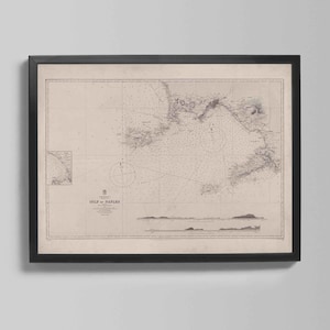 May include: Framed vintage nautical chart of the Gulf of Naples, Italy. The map features detailed coastlines, depth soundings, and navigational information. The chart is printed in sepia tones and framed in a black wooden frame, perfect for nautical decor.