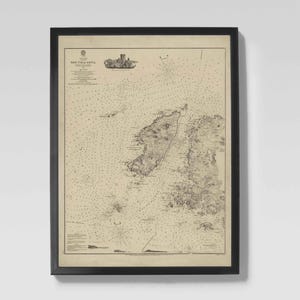 May include: Framed vintage nautical chart with a black frame. The chart features detailed illustrations of coastlines, islands, and navigational elements. The text "SOUND of ISLAY" is visible at the top. The map is printed in sepia tones.