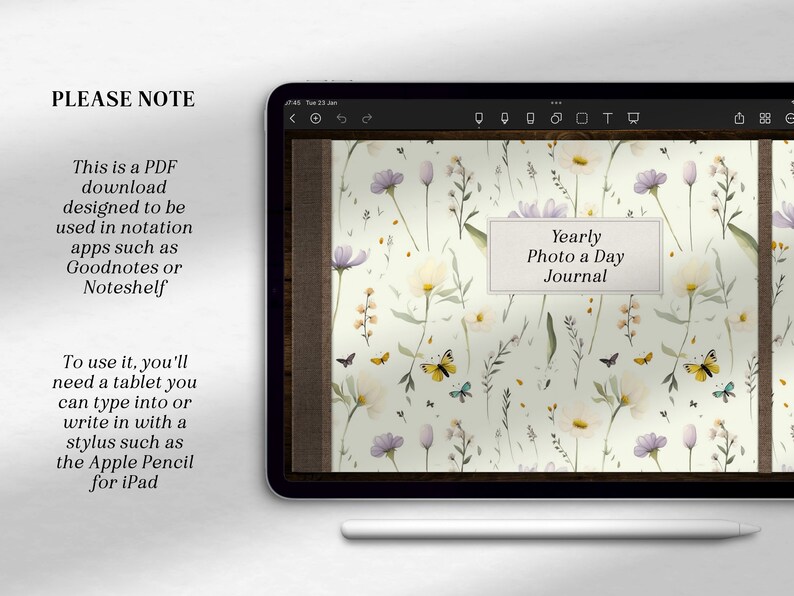 Puede incluir: Una tableta digital que muestra una descarga PDF para un "Diario de fotos diario anual". La portada del diario presenta un patr&oacute;n floral con mariposas y el texto "Diario de fotos diario anual". La tableta est&aacute; sobre una superficie blanca con un l&aacute;piz blanco.