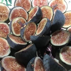 May include: A close-up of several fresh figs, some halved, showcasing their deep purple skin and reddish-pink flesh. The figs are arranged in a pile, highlighting their natural colors and textures. The image captures the freshness and appeal of the fruit.