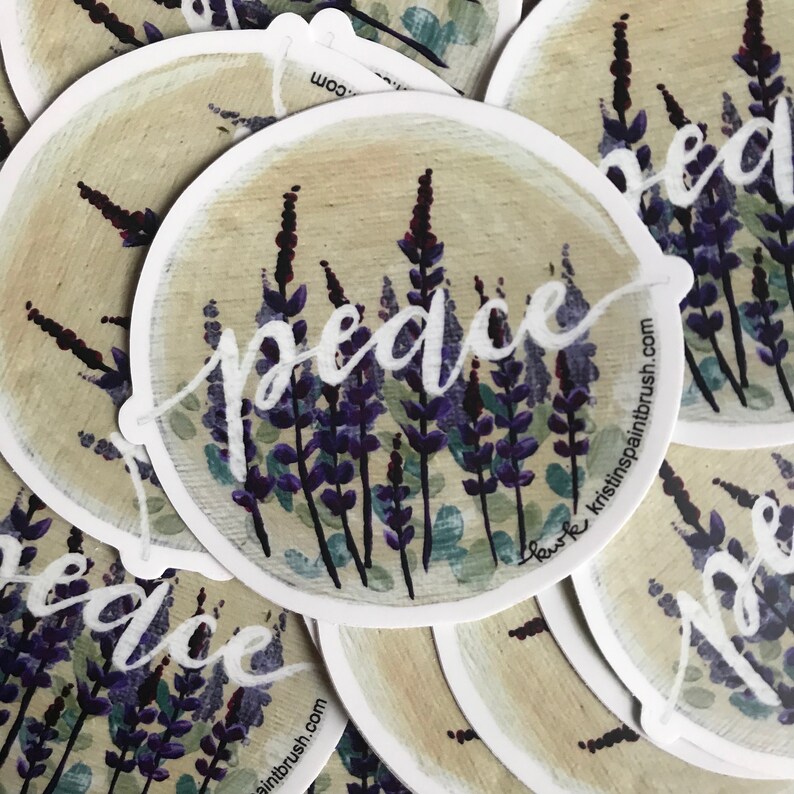 May include: Round sticker with a watercolor illustration of purple lavender flowers and the word "peace" in white script. The sticker has a white border and the website "kristinspaintbrush.com" is printed on the bottom right corner.