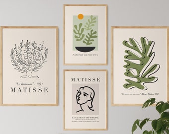 以下が含まれることがあります： 植物と肖像画の抽象的な線画を描いた、額装されたアートプリント4点。プリントは薄い茶色の額縁で、白い背景になっています。プリントのテキストは「PAPIERS DECOUPES」、「MATISSE」、「Le Rouisson - 1951」、「We cannot see our own face」- Henri Matisse 1952です。