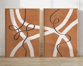 May include: Two abstract art prints with a brown background and white and black lines. The prints are framed in gold.