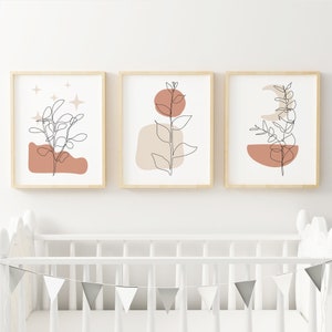 May include: Three minimalist line art prints with a neutral color palette. Each print features a single line drawing of a plant with abstract shapes in shades of brown and beige.