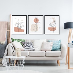 May include: Three minimalist line art prints with a neutral color palette. Each print features a branch with leaves and a geometric shape in shades of brown and beige.