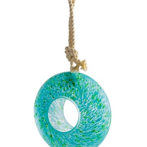 May include: A turquoise glass bird feeder with a speckled green and white design. The feeder is suspended from a white rope with a copper hook.